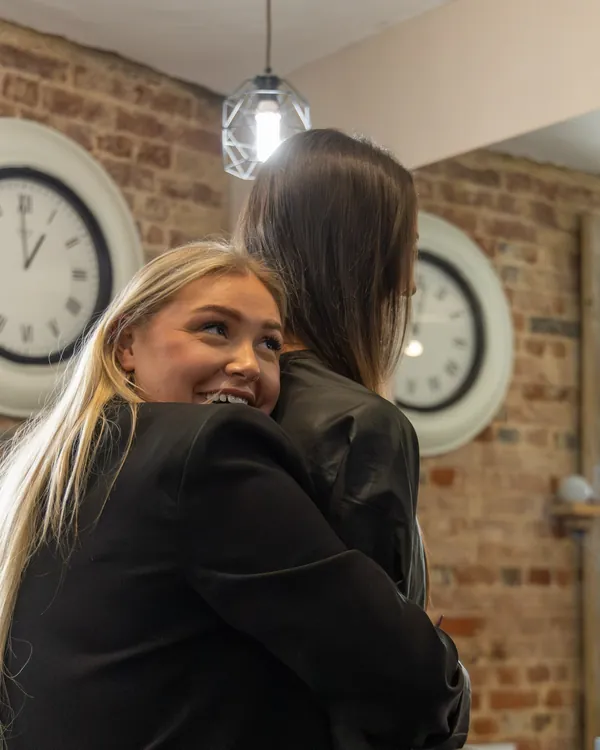 Two of the team hugging in the salon